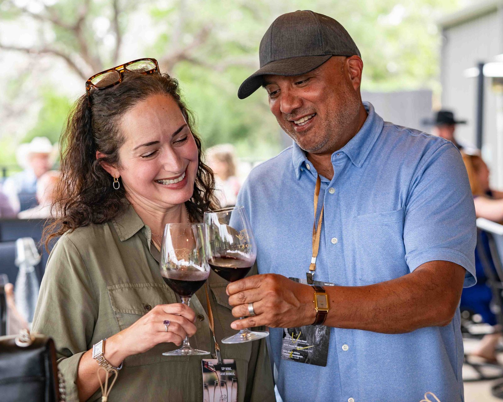 Two members toasting with red wine under the pavilion at a Member Bash